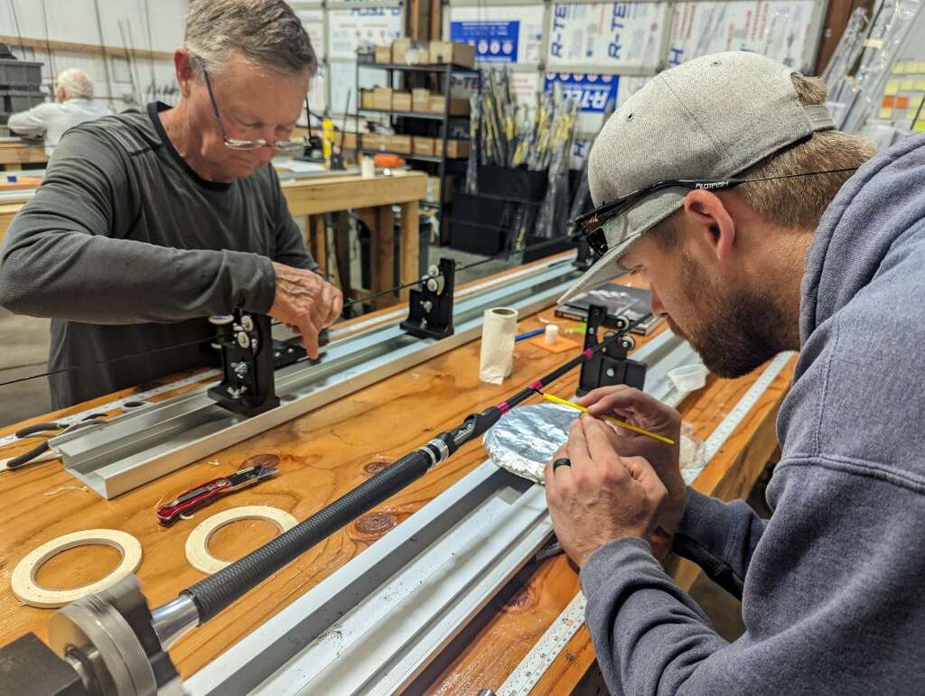 Instructor guiding a student while wrapping guides during a rod building workshop