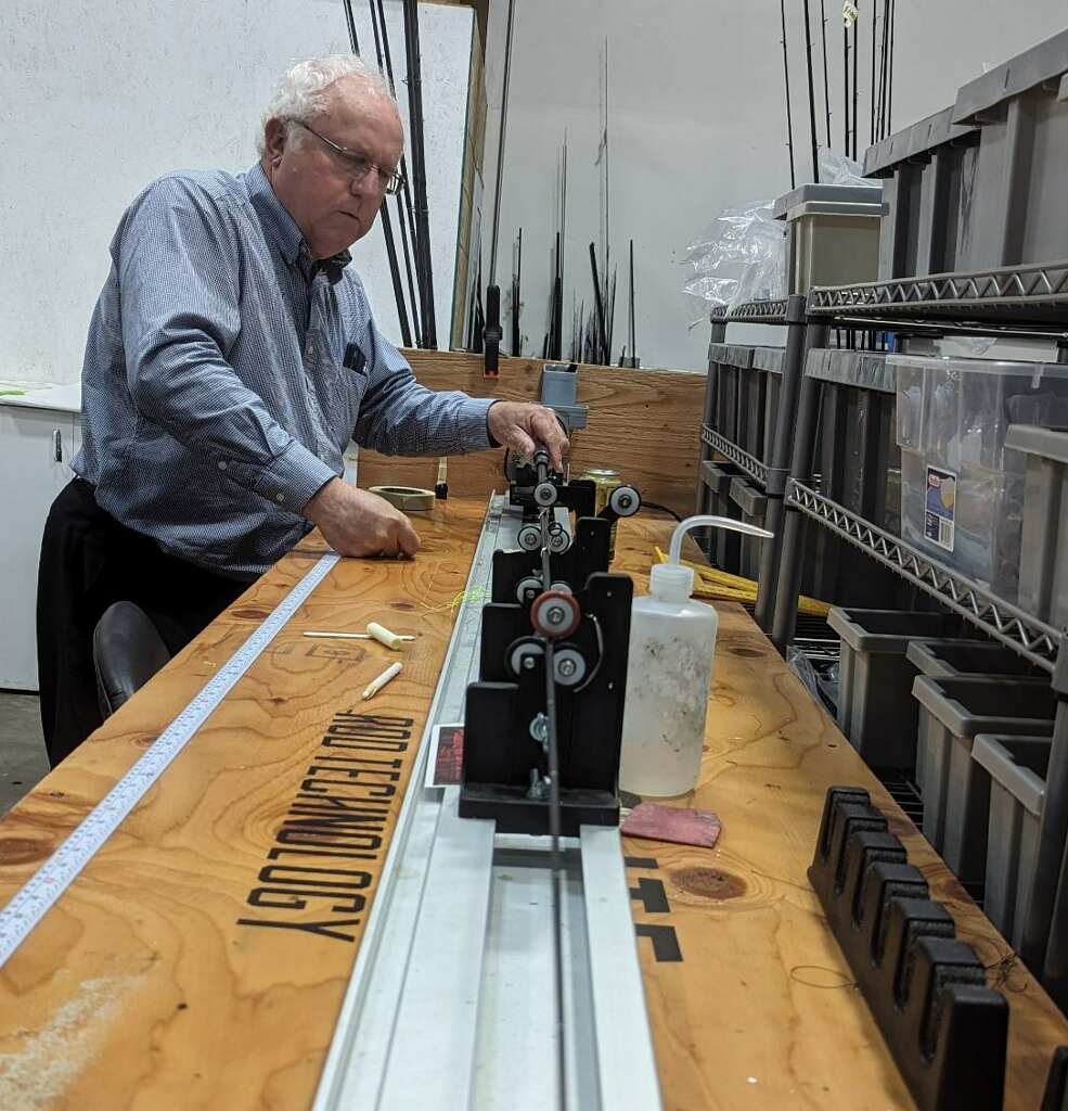 Angler aligning guides on a rod building wrapper at the Prolite shop